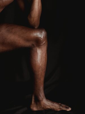 Muscular Naked Man Leg on Black Studio Background