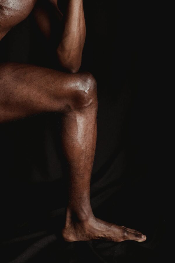 Muscular Naked Man Leg on Black Studio Background